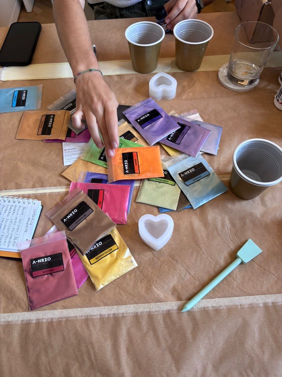 Pigmenti colorati e stampi a cuore sul tavolo del workshop